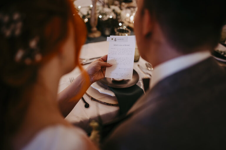 Green Fairytale Wedding - Hochzeitsinspiration - Styled Shooting Brautpaar am gedeckten Tisch mit Menuekarte