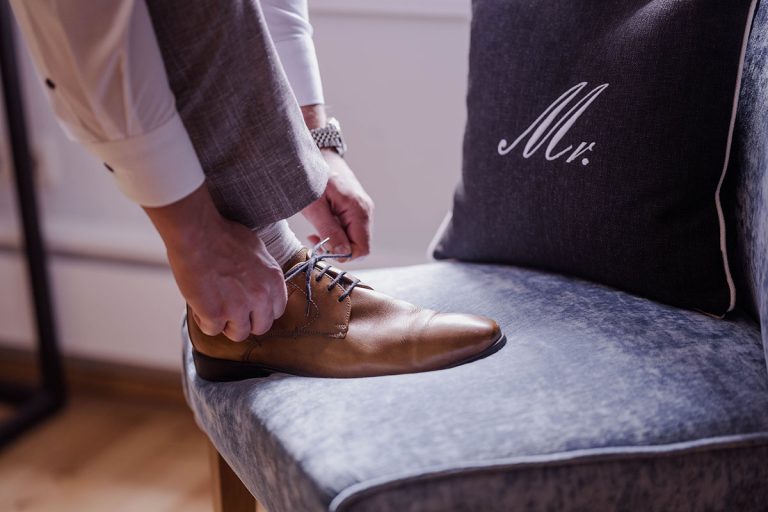 Braeutigam beim Binden seiner Hochzeitsschuhe
