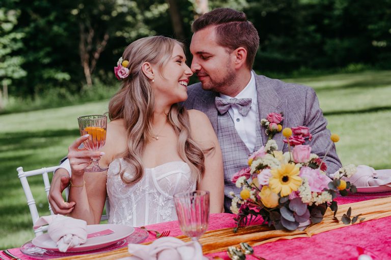 Brautpaar am gedeckten Tisch bei der Hochzeitsfeier