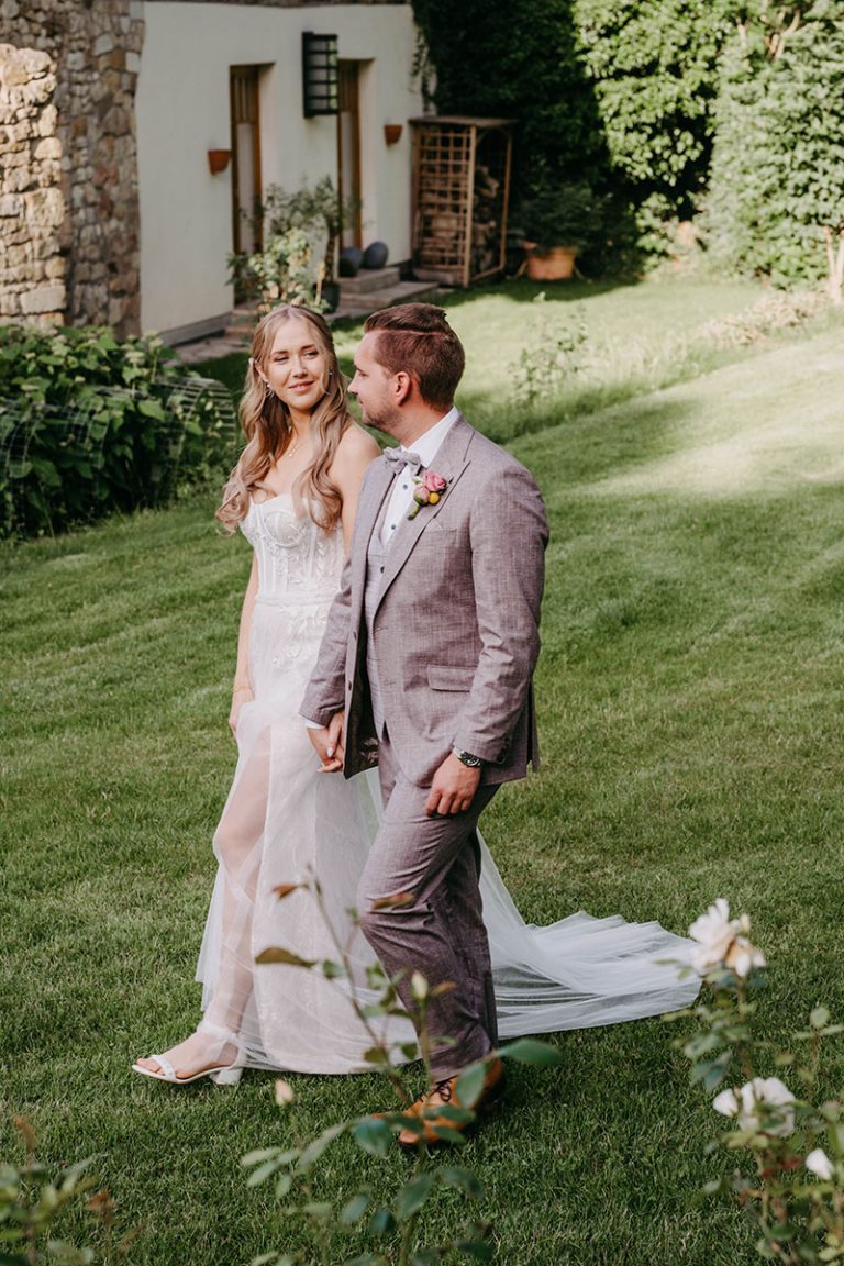 frisch verheiratetes Ehepaar schlendert zur Hochzeitsfeier