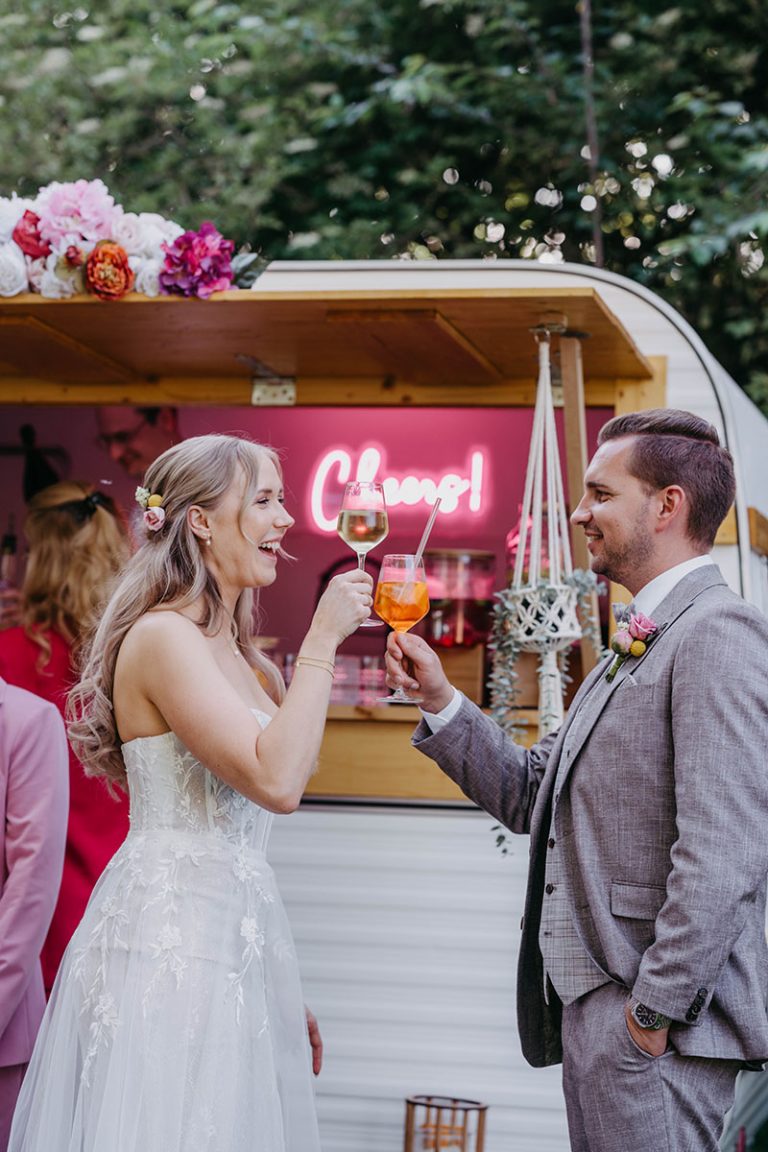 Brautpaar stoesst gemeinsam mit den Gaesten an